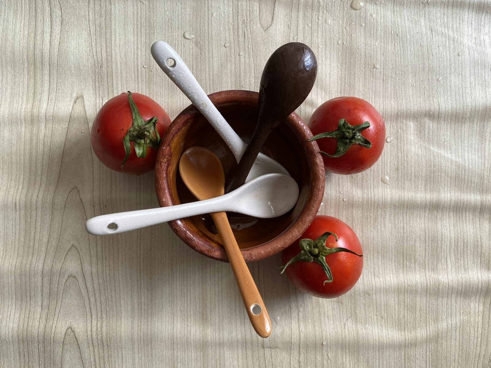 Tomat merah dan sendok kayu di mangkuk keramik merah, bahan segar untuk meal plan MPASI